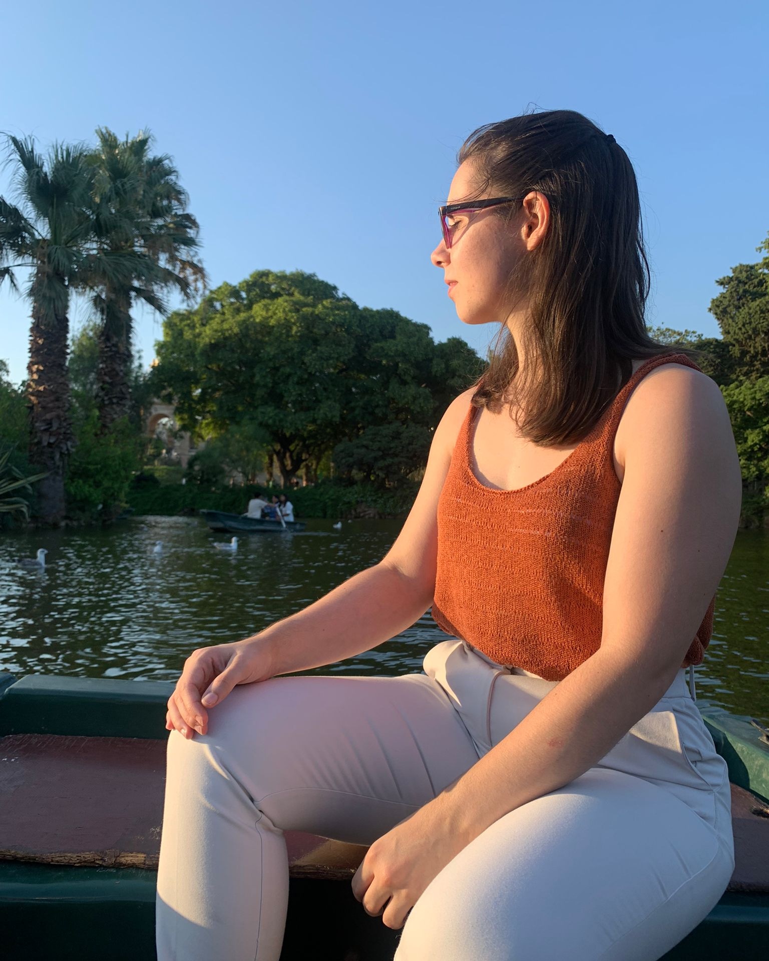 Una mujer sentada en una barca en medio de un lago tranquilo